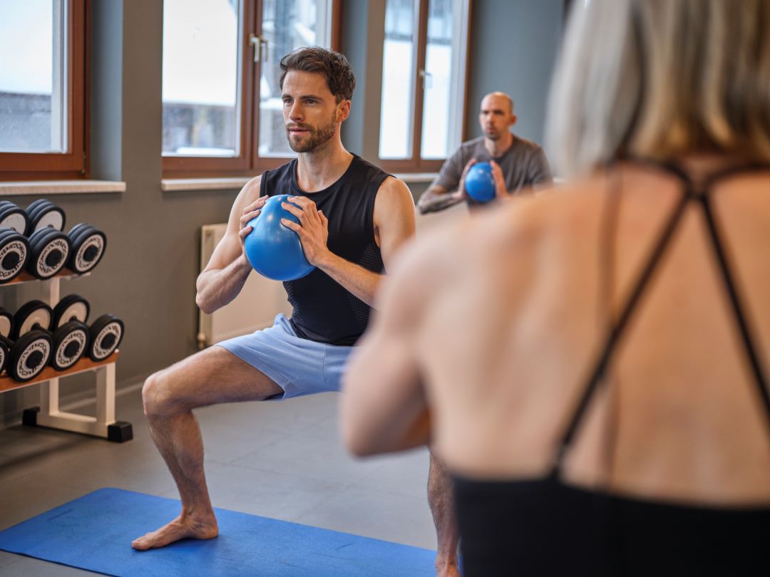 Menschen beim Sport im Kursraum, Sportkurs