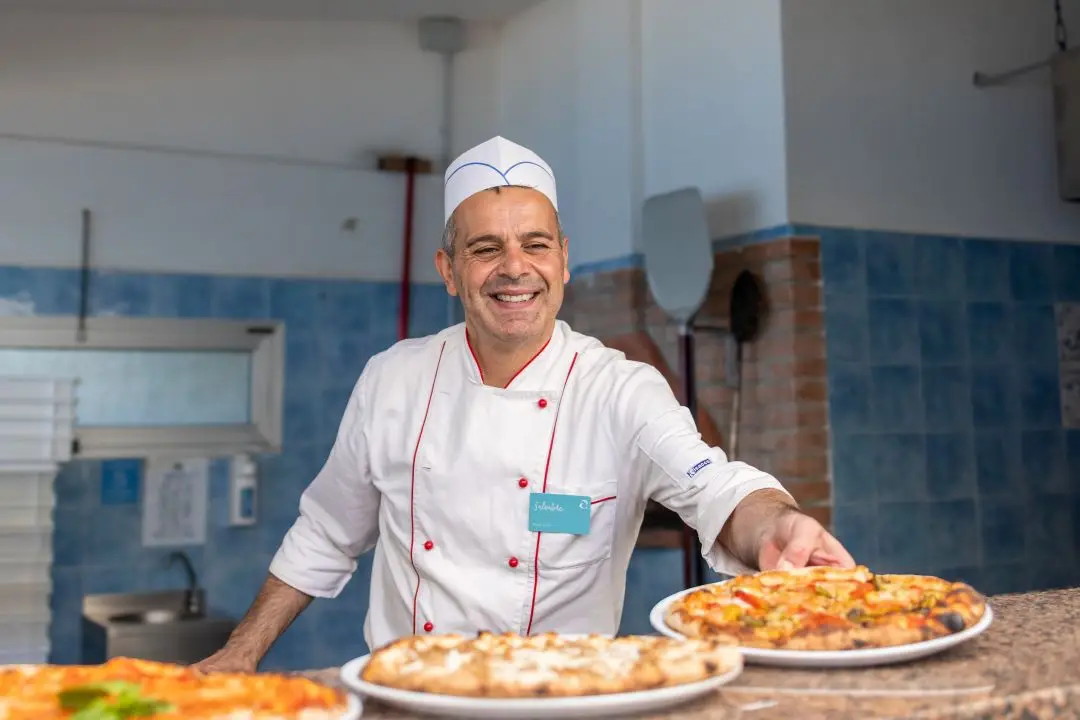 Koch im Hotel, Pizza, Pizzaofen, Essen zubereiten für Gäste 